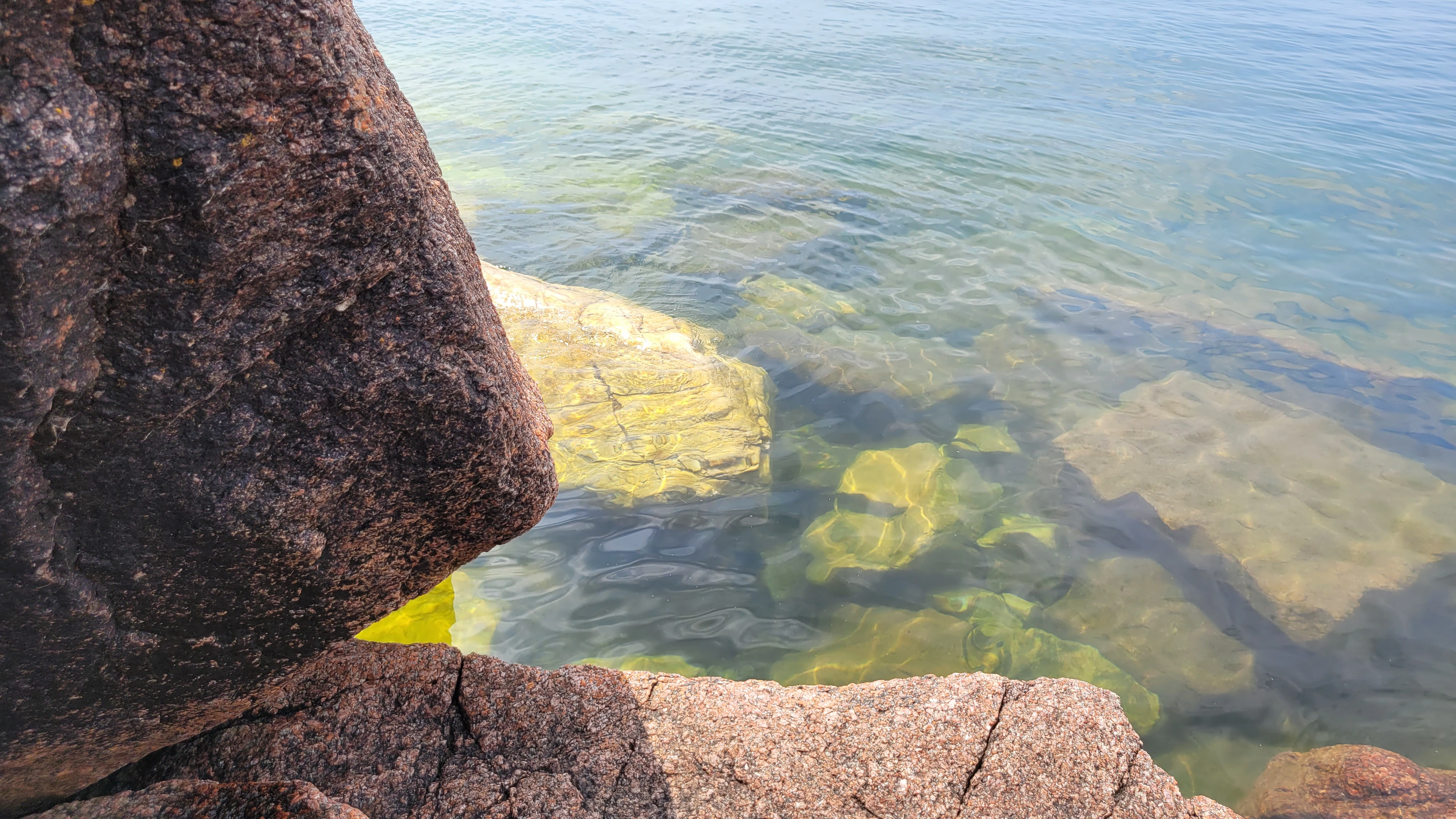 Western Shoreline of the Benjamind islands with red granite rock, white quartzite,
                trees and clear water